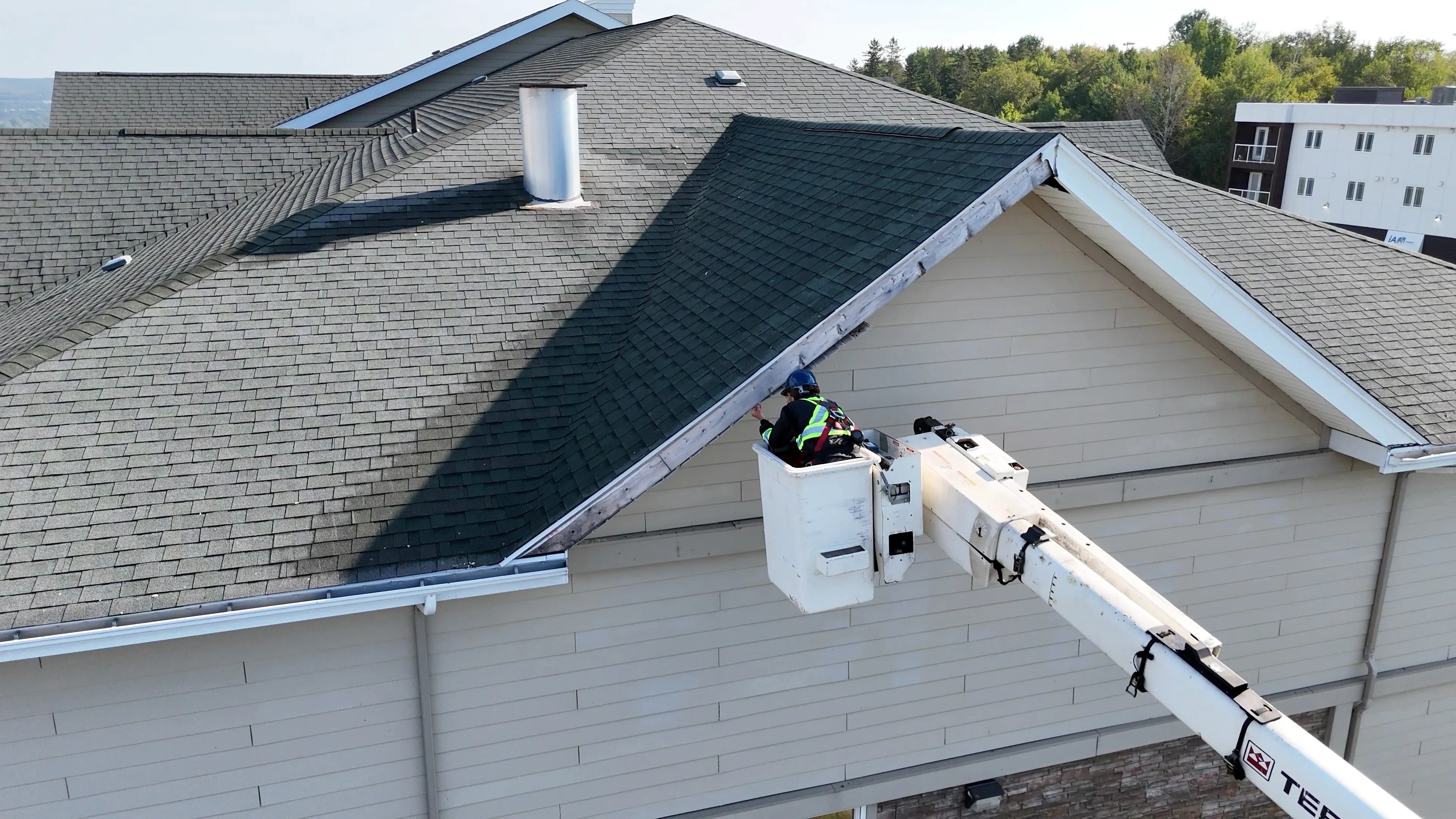a simply seamless employee working on a hotel fascia